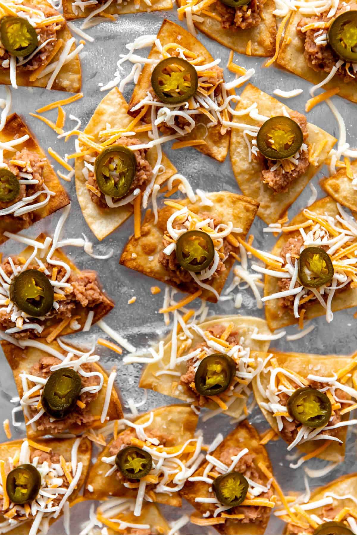 Tortilla chips topped with refried beans, grated cheese, and pickled jalapeños.
