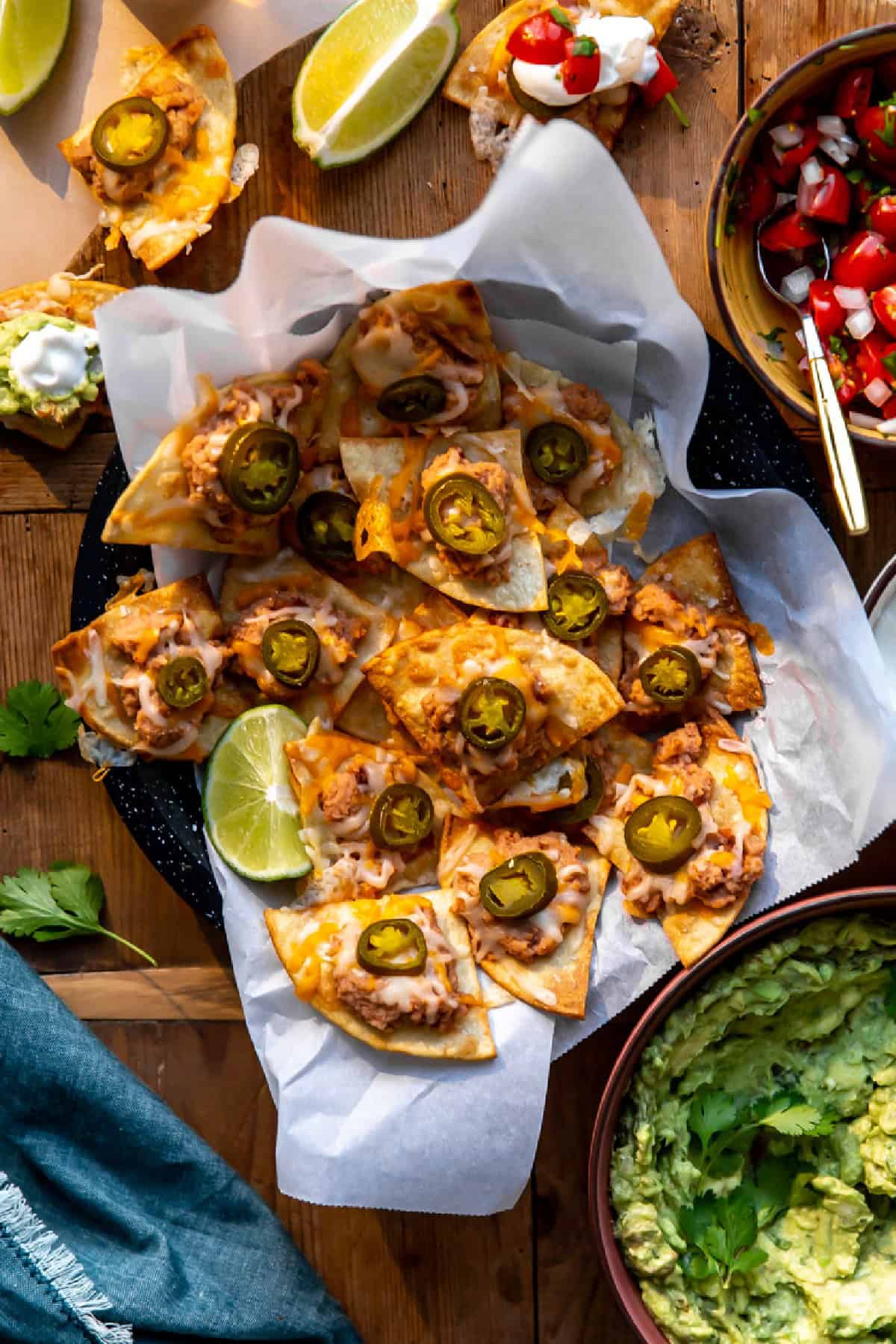 Texas nachos served on a dish with pico and guacamole on the side.
