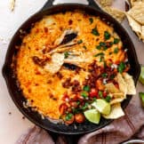 stretchy melted cheese in a skillet with chorizo and pico de Gallo.