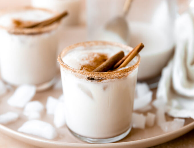 Glass rimmed with cinnamon and filled with cold and creamy homemade horchata, served with cinnamon sticks.
