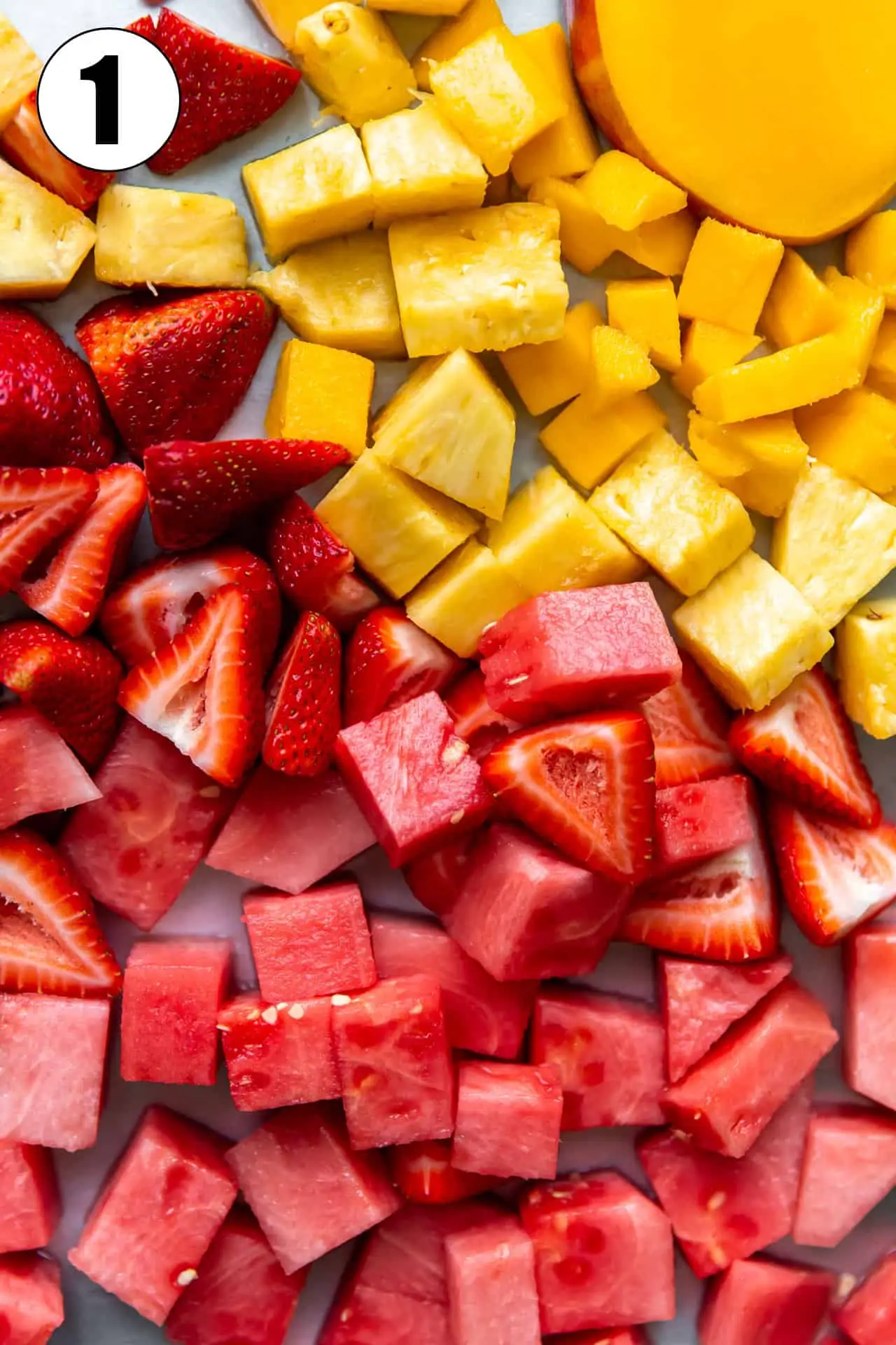 Chopped fruits laid spread out, watermelon, strawberry and mango. 