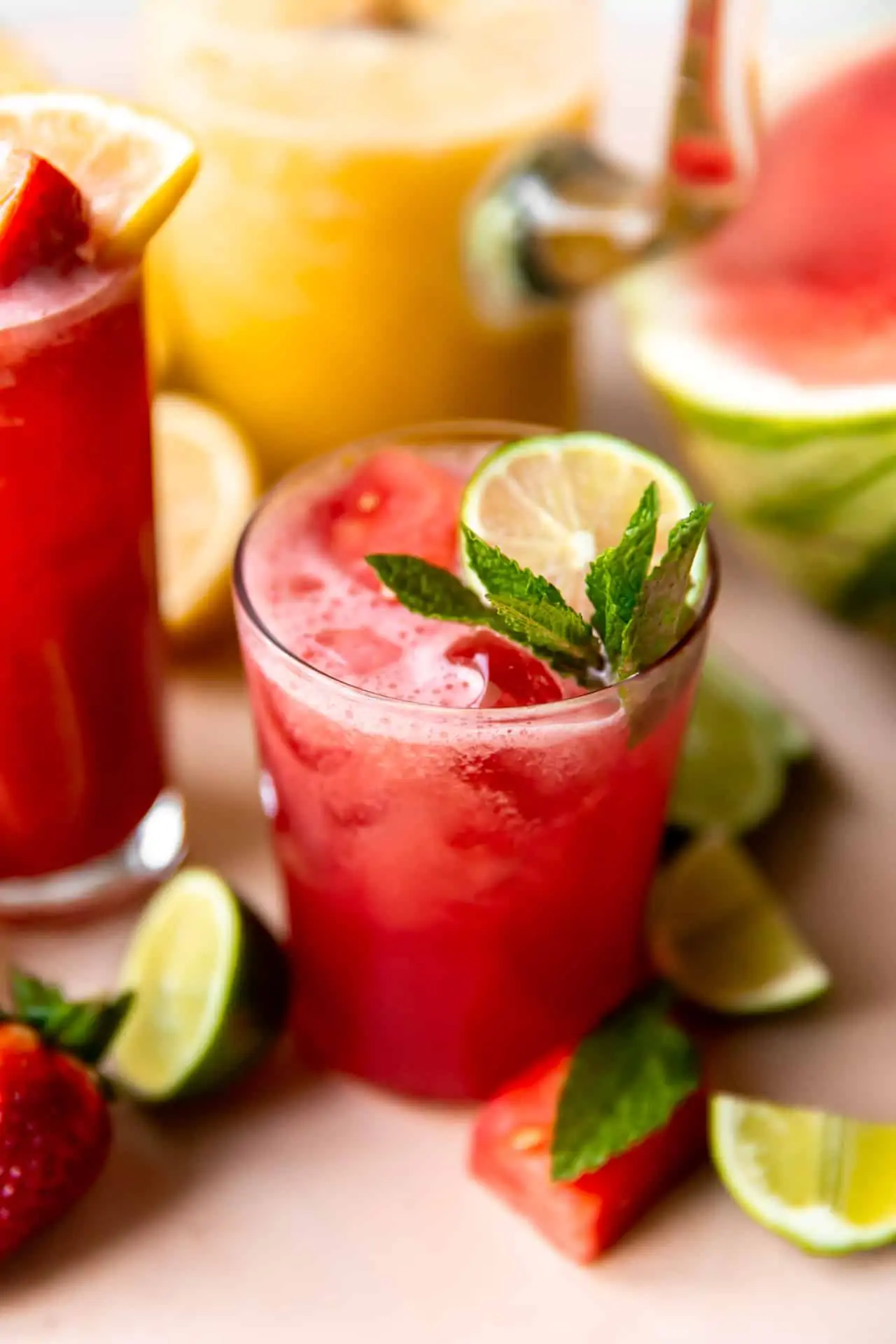 Glass of watermelon agua fresca garnished with mint and lime. 