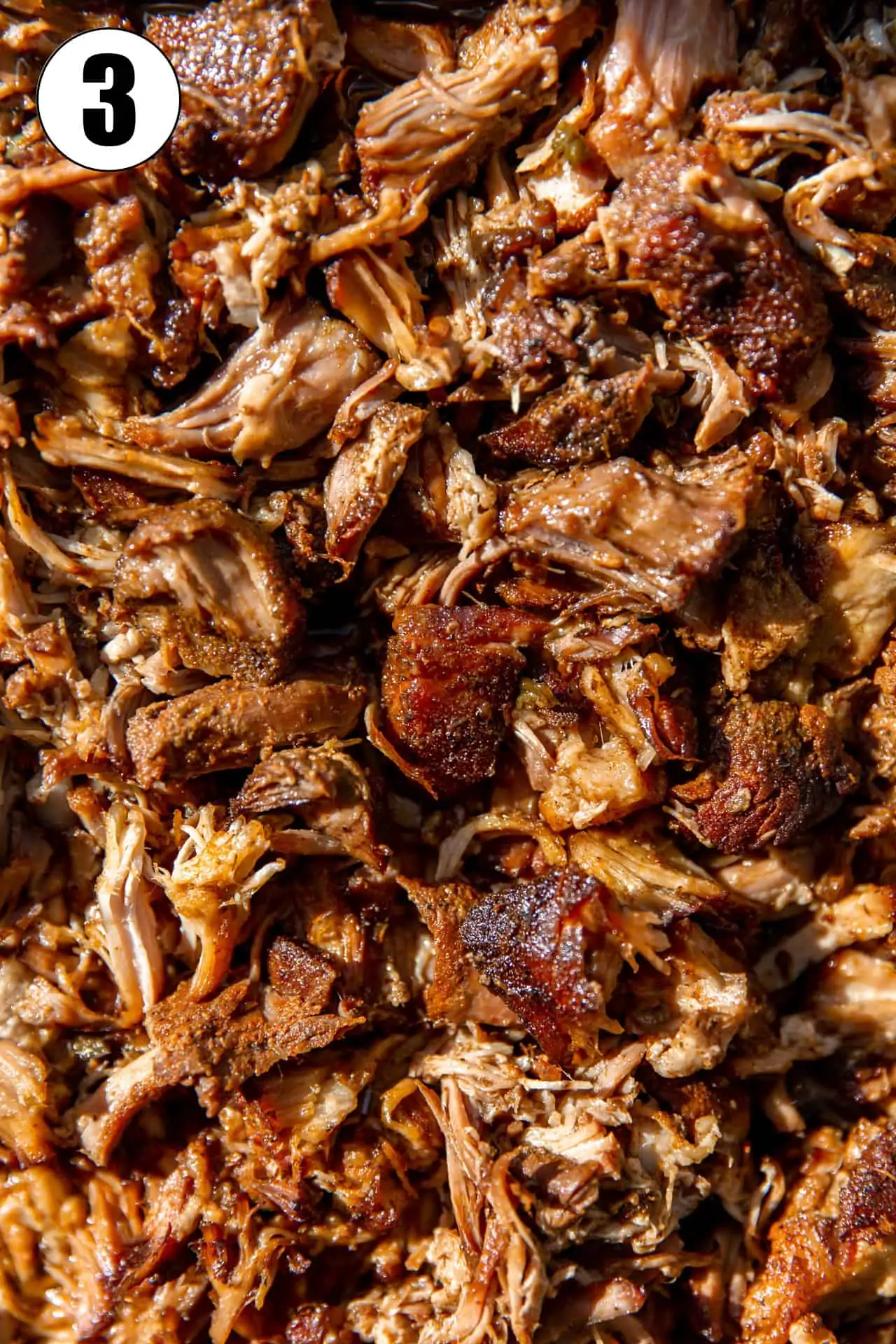 Up close view of shredded pork that has been crisped under a broiler.