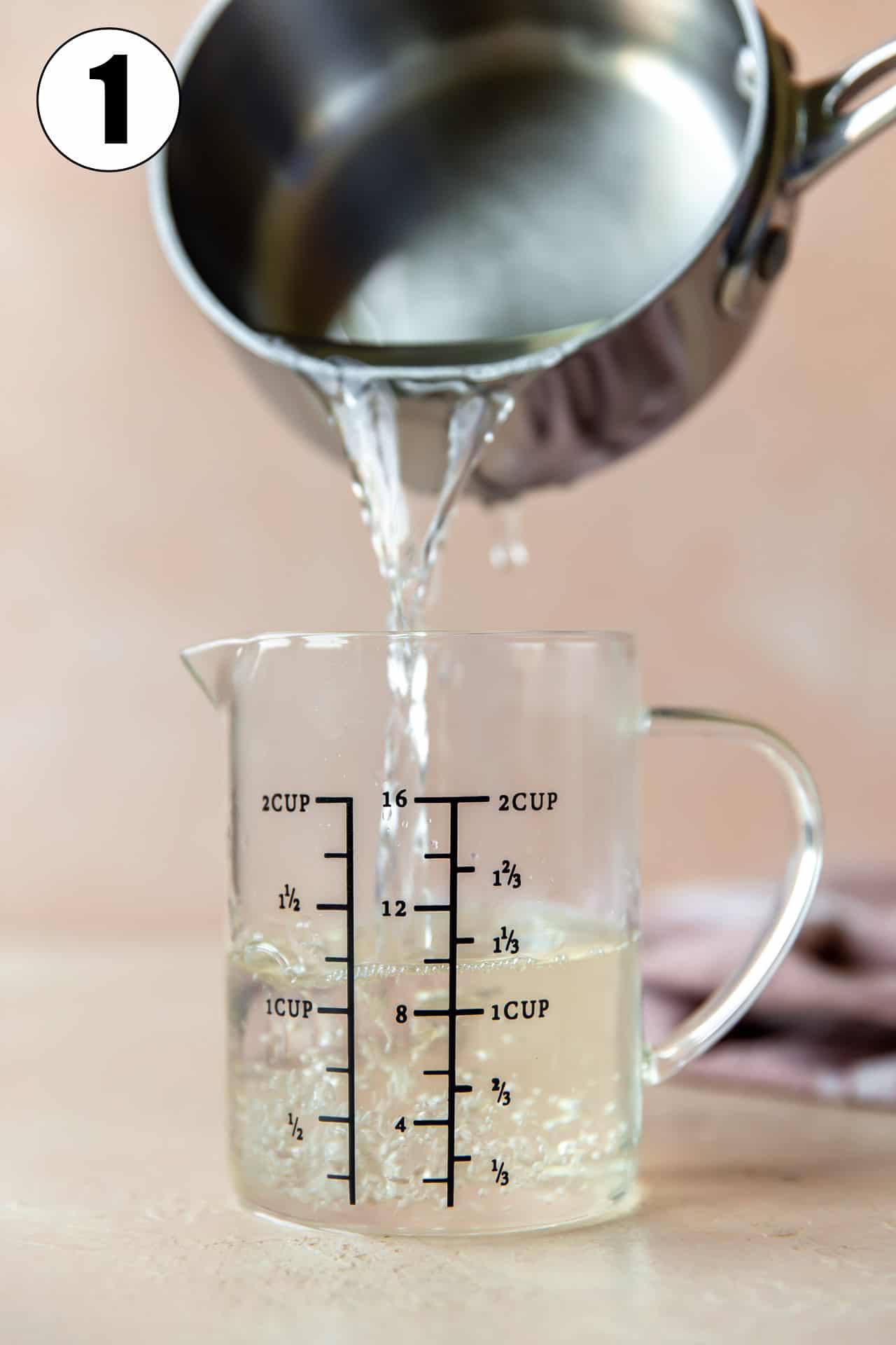 Simple syrup being poured into a measuring cup. 