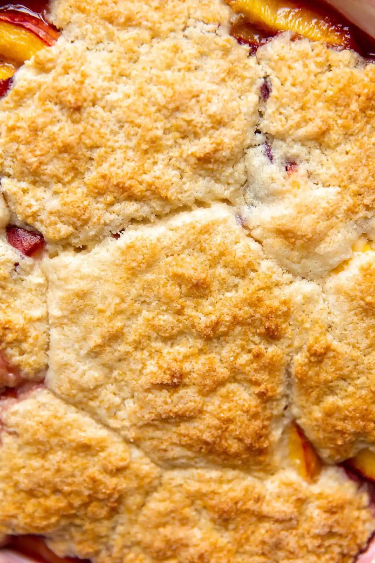 Baked peach cobbler, showing a cobbled top. 