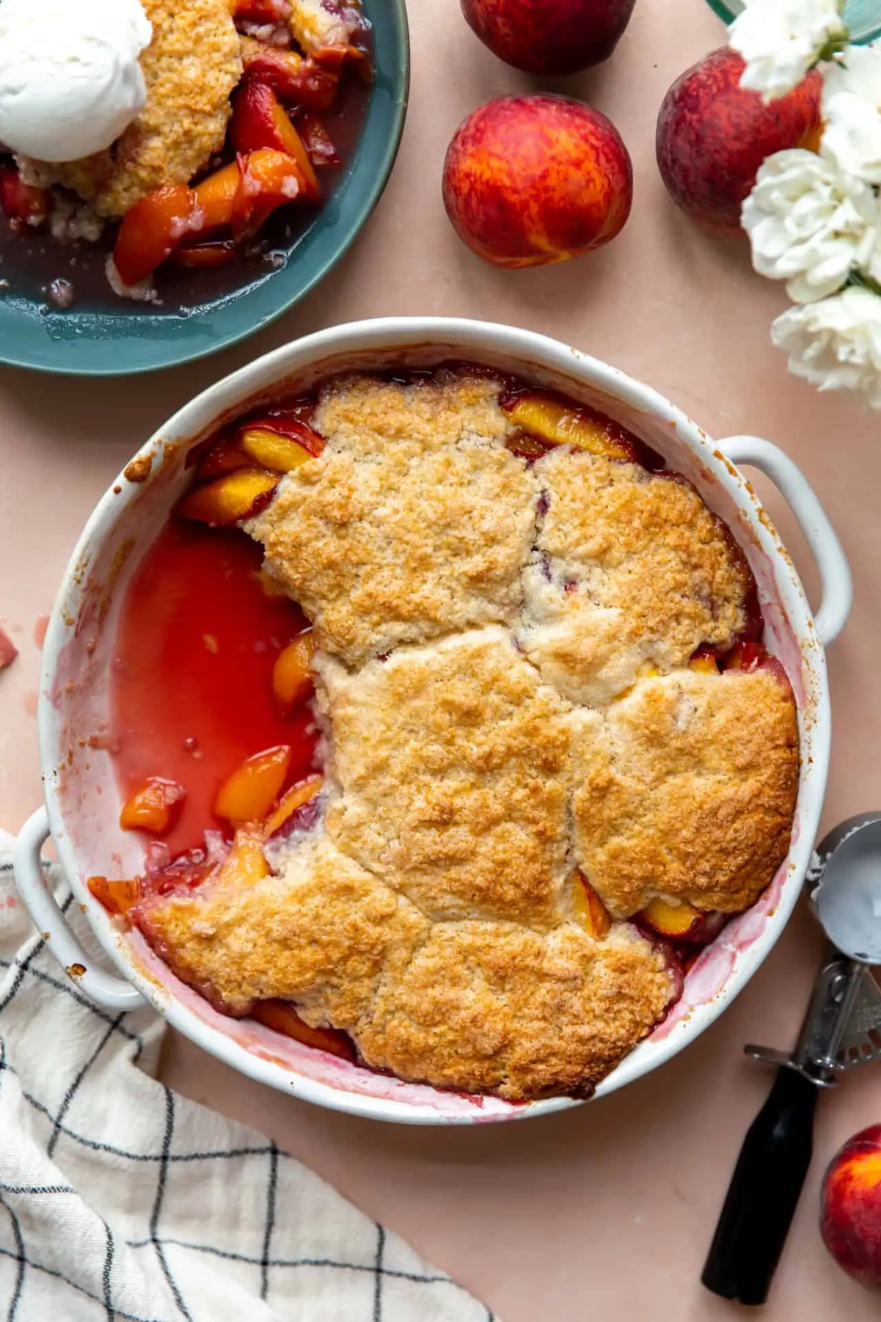 Baked peach cobbler in a round dish.