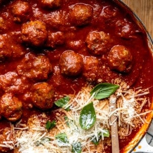 Easy homemade meatballs in a skillet with tomato sauce and topped with parmesan.