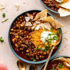 Bowl of taco soup served with cheese, sour cream and tortilla chips.