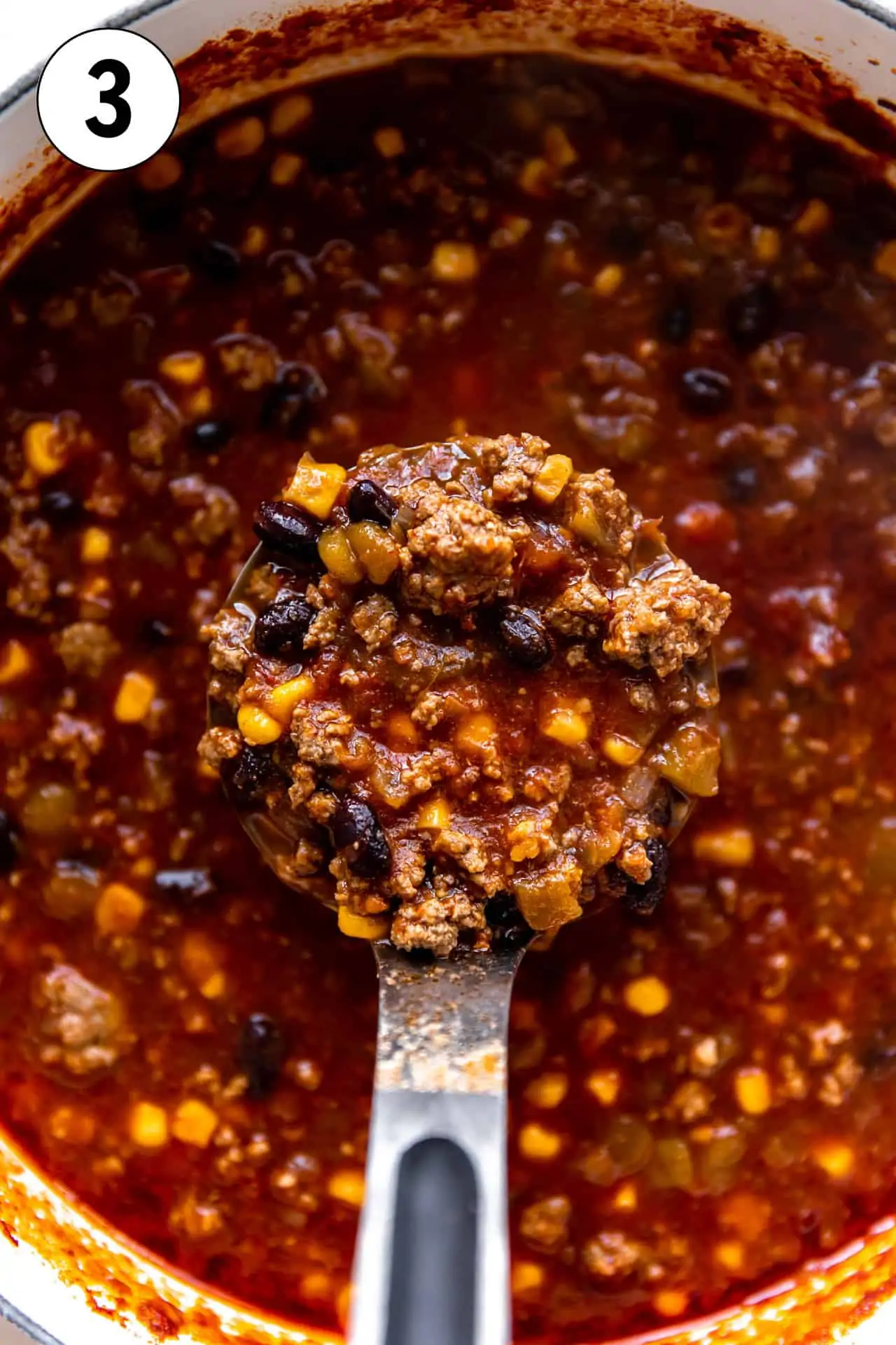 Ladle spooning up a thick hearty taco soup.