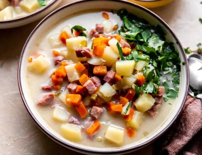 Bowl of ham bone soup served with fresh parsley on top.