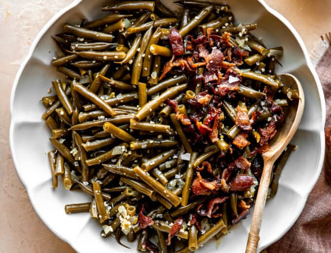 Dish of southern green beans topped with crispy bacon.