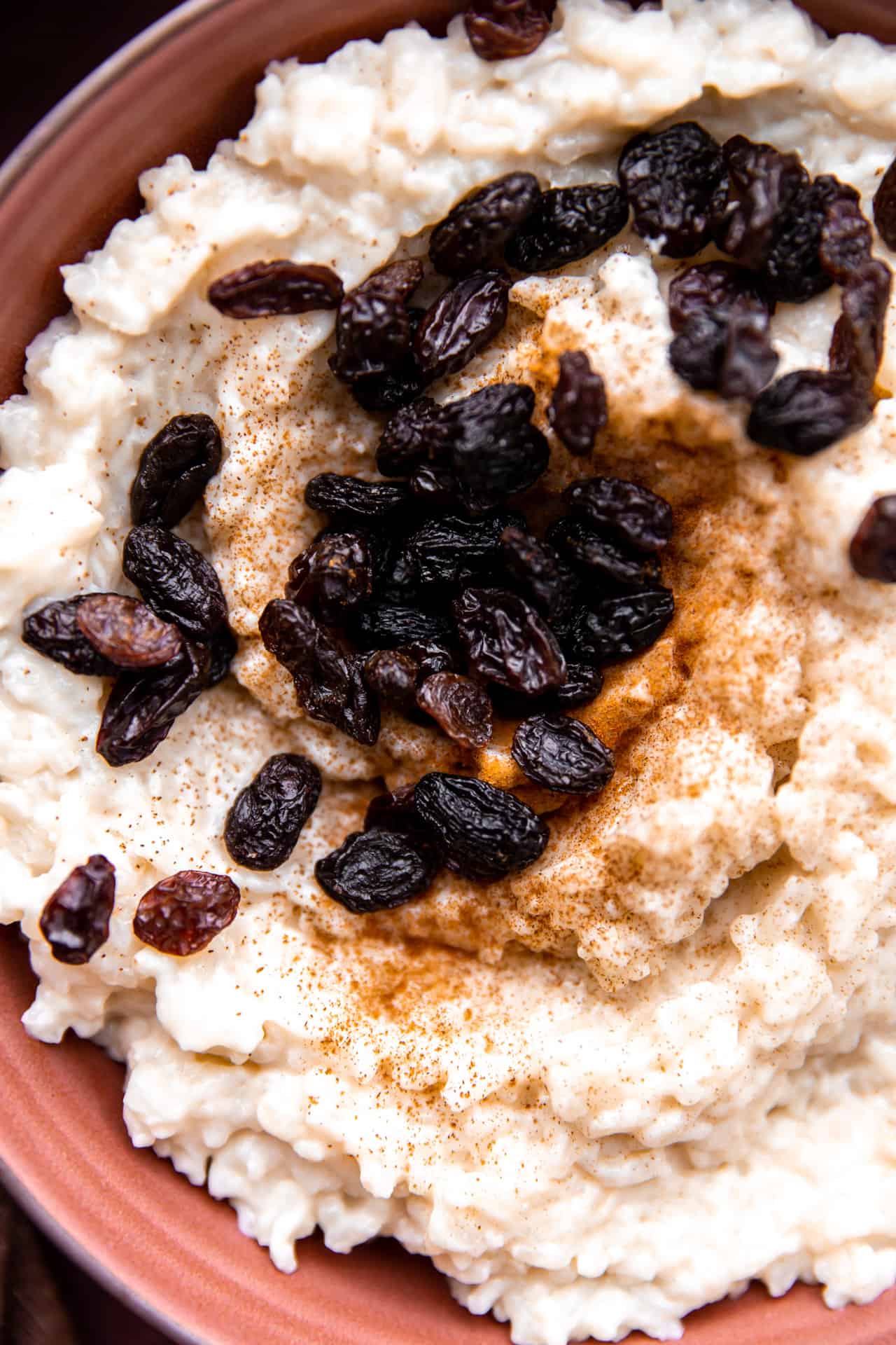 Up close view of raisins on top of arroz con leche.