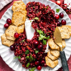 Cranberry Salsa served on a plate over cream cheese with crackers.