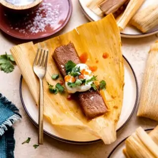 Pork tamales topped with sour cream, cilantro and hot sauce.