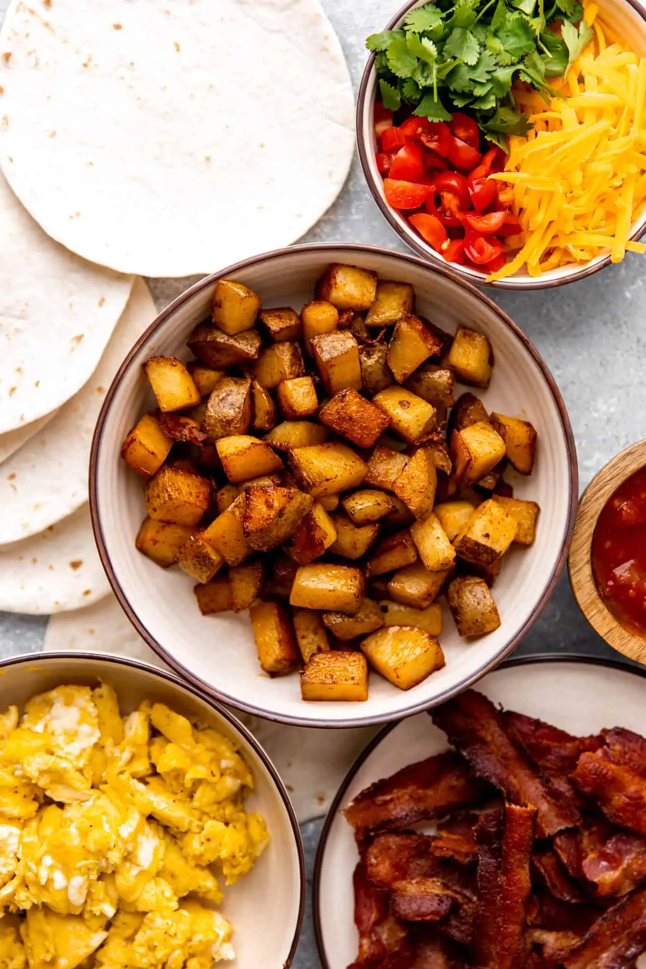 All the ingredients and toppings laid out to assemble breakfast tacos.