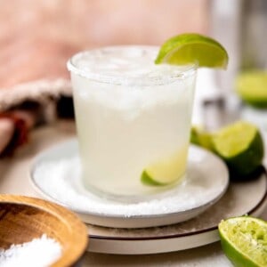 A perfect classic margarita garnished with salt rim and a wedge of lime.