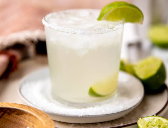 A perfect classic margarita garnished with salt rim and a wedge of lime.