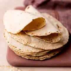 Stack of homemade corn tortillas folded over.