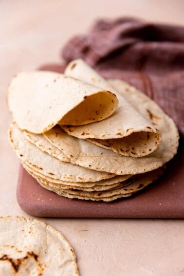 Stack of homemade corn tortillas folded over.