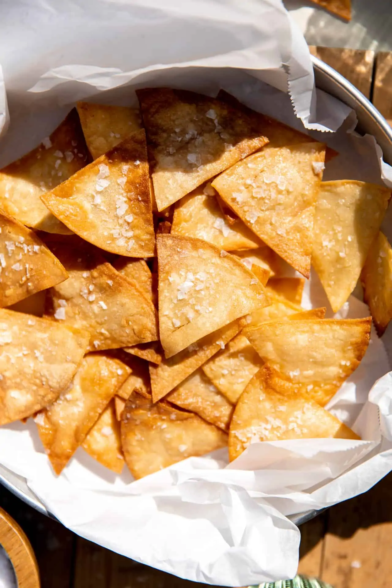 Up close look at homemade tortilla chips topped with flakey salt.