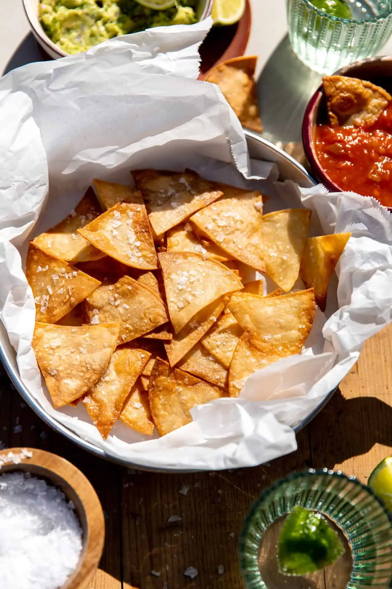 Basket of homemade salted tortillas chips served with salsa and guacamole.