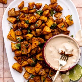 Plate of roasted tex mex seasoned potatoes served with queso.