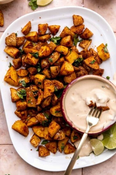 Plate of roasted tex mex seasoned potatoes served with queso.