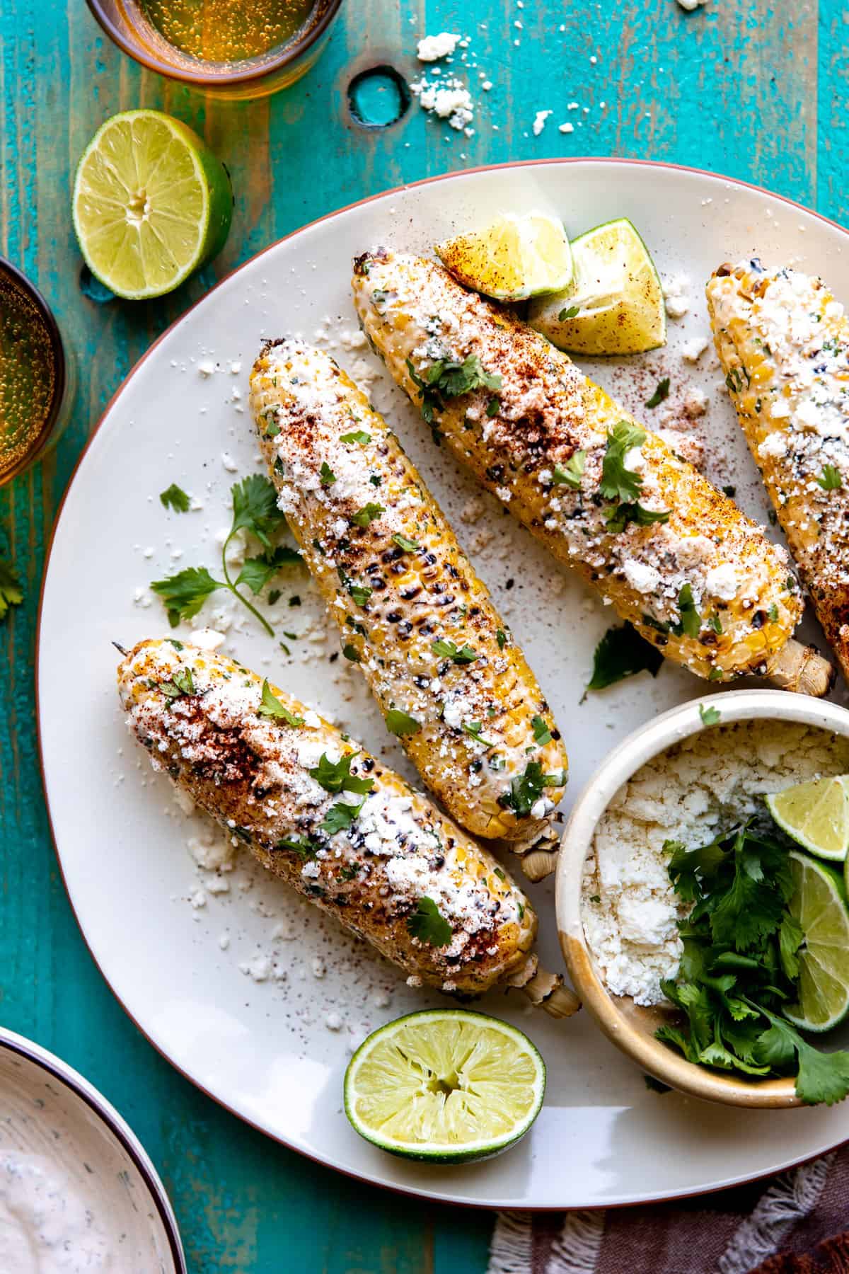 Plate with homemade elotes topped with chili powder, cotija and cilantro.