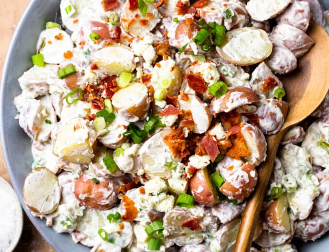 Overhead view of creamy red potato salad being served with a spoon.