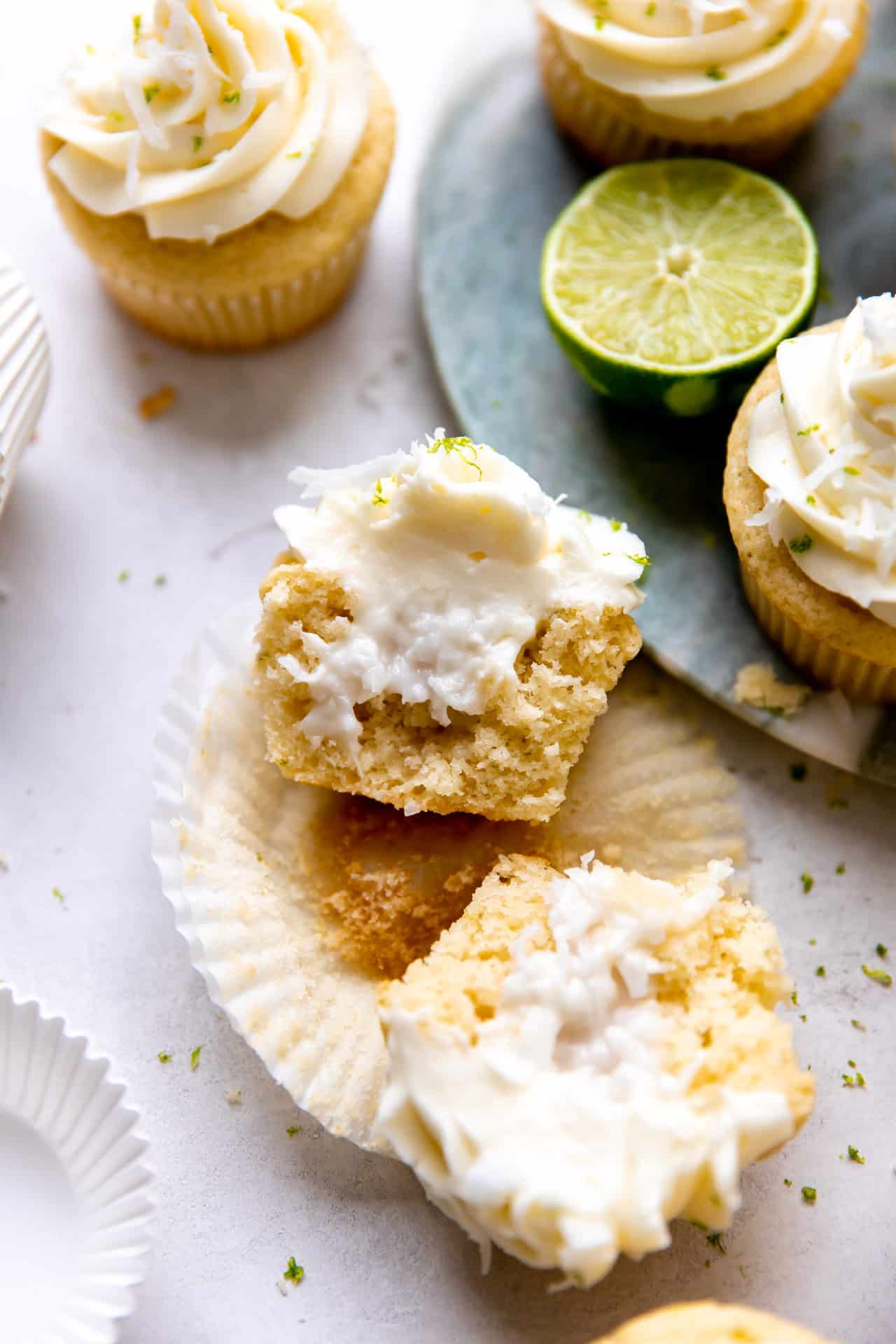 Sliced open coconut lime cupcake showing creamy coconut filling in the middle.