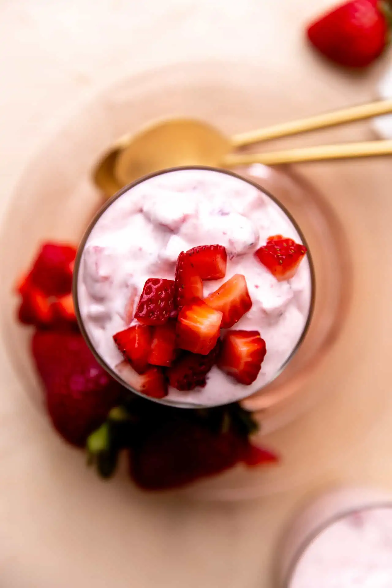 Overhead view of fresas con crema served with cut strawberries on top. 