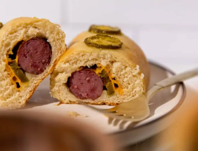 Cut open kolache with sausage, jalapeno and cheese.