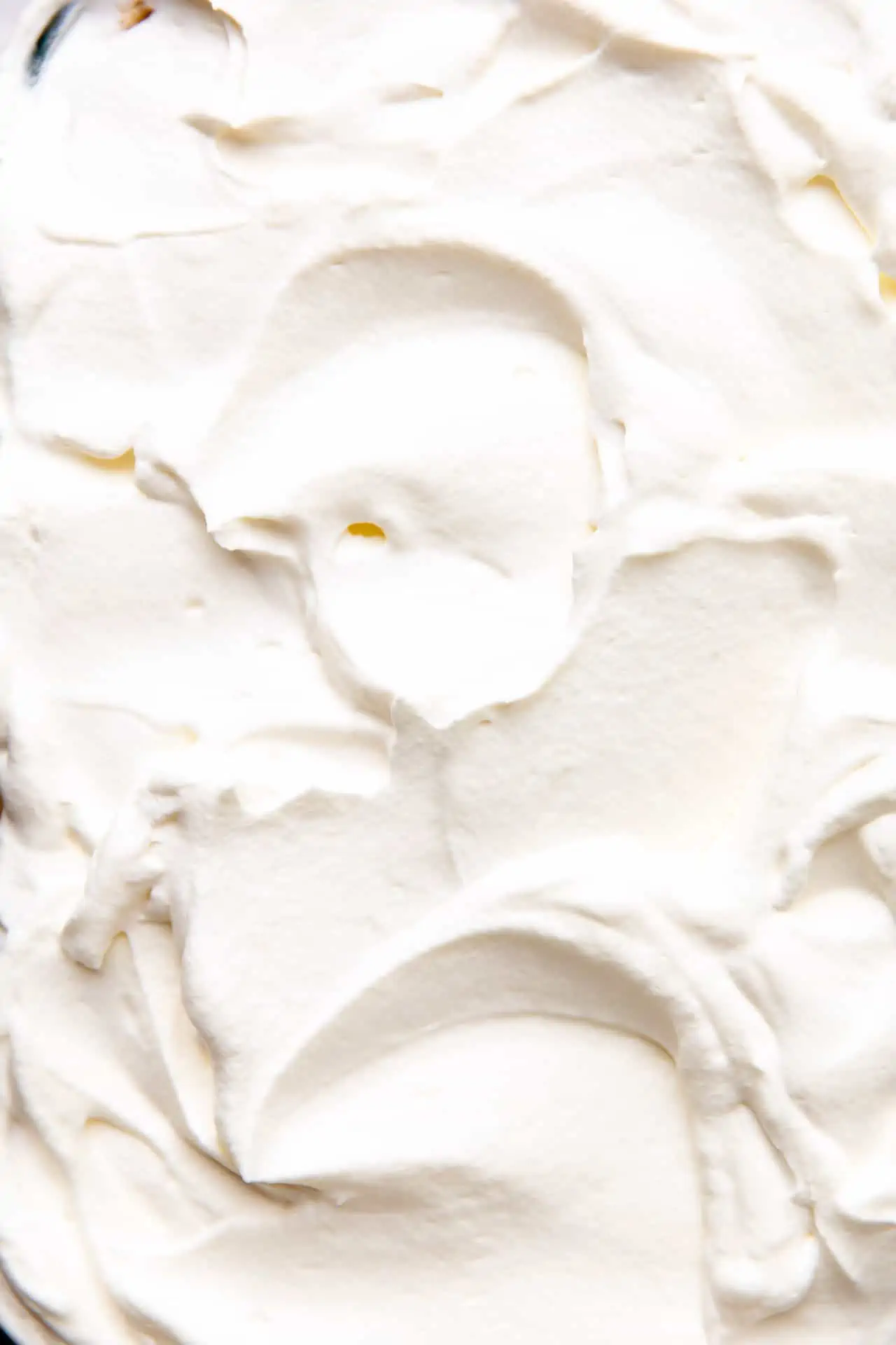 Whipped cream spread over the top of banana pudding for chilling. 