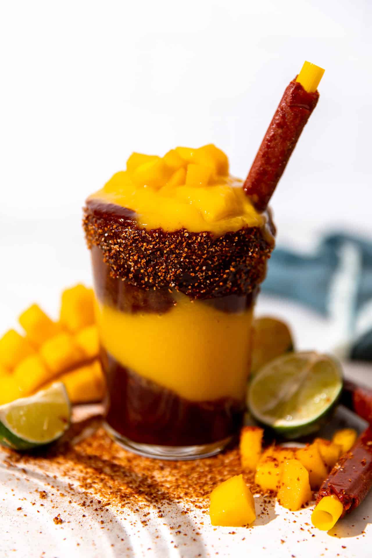 Glass filled with homemade mangonada topped with chamoy and more mango. 