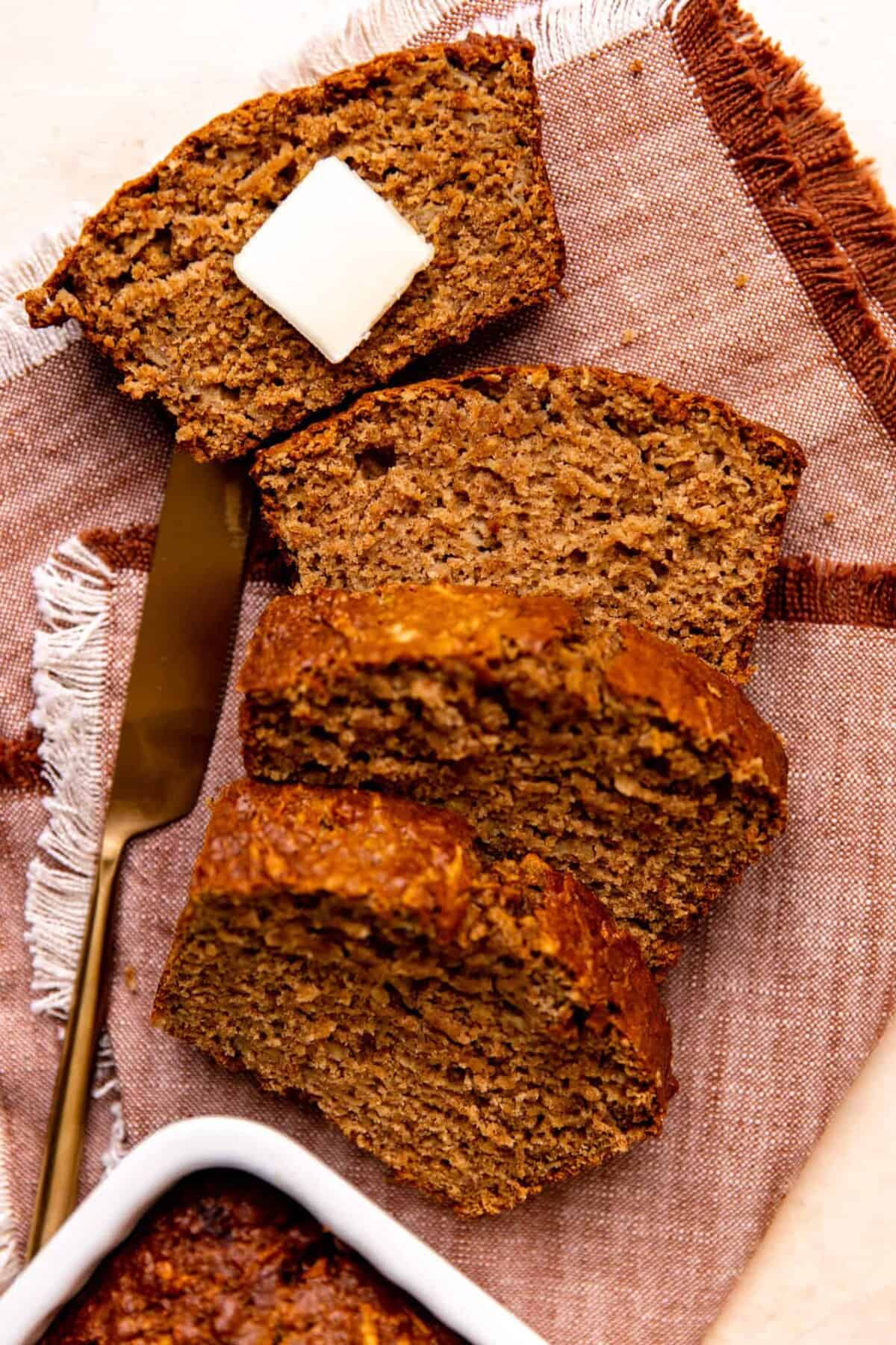 Slices of apple bread laid out with a slab of butter on top.