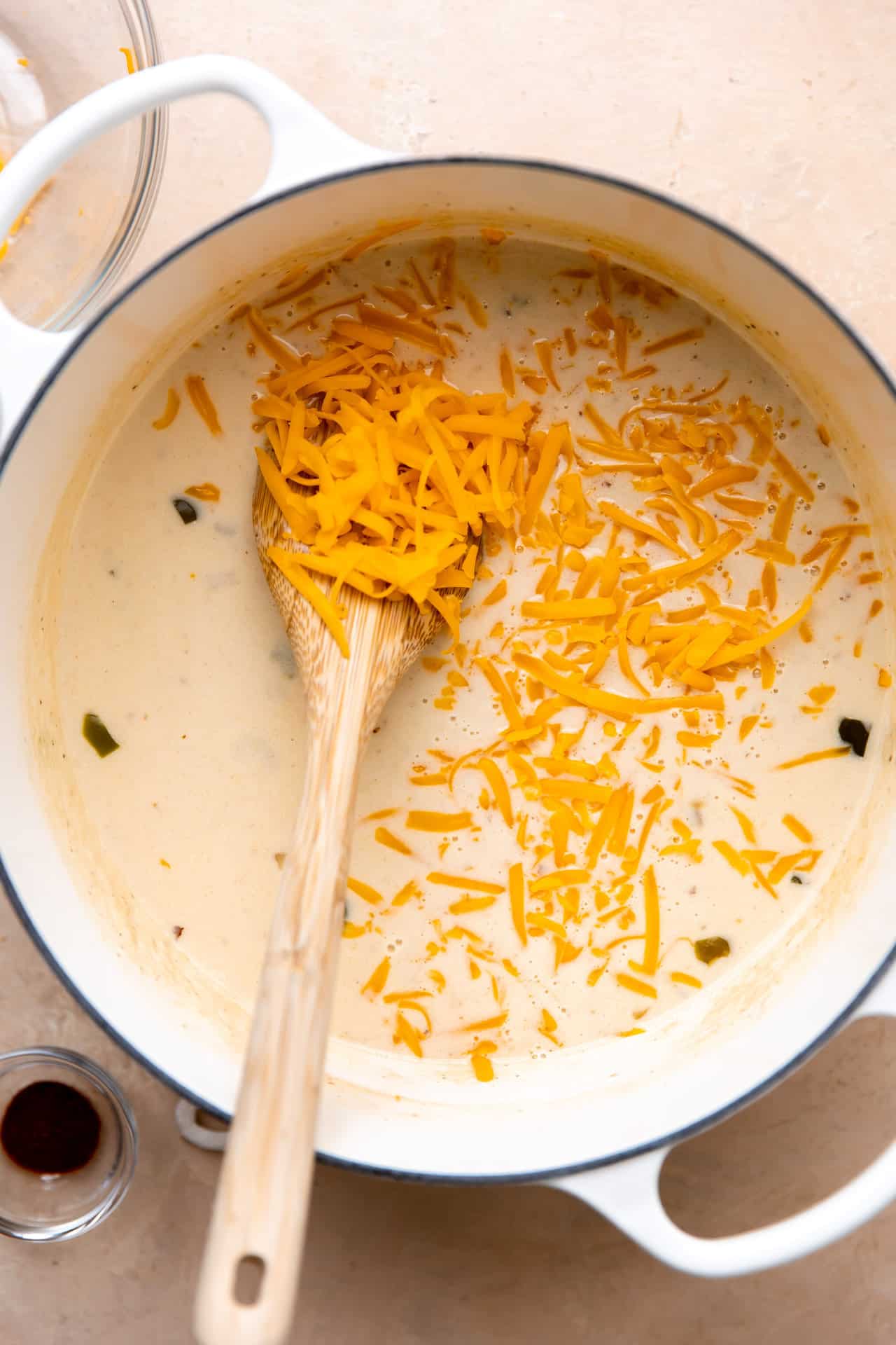 How to make beer cheese soup, showing creamy broth and cheese being added.