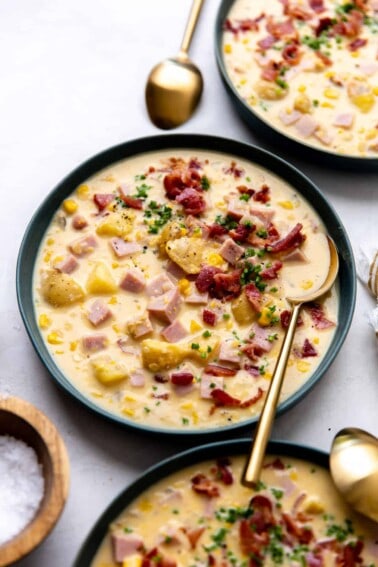 Bowl of corn chowder topped with crispy bacon and garnished with fresh chives.