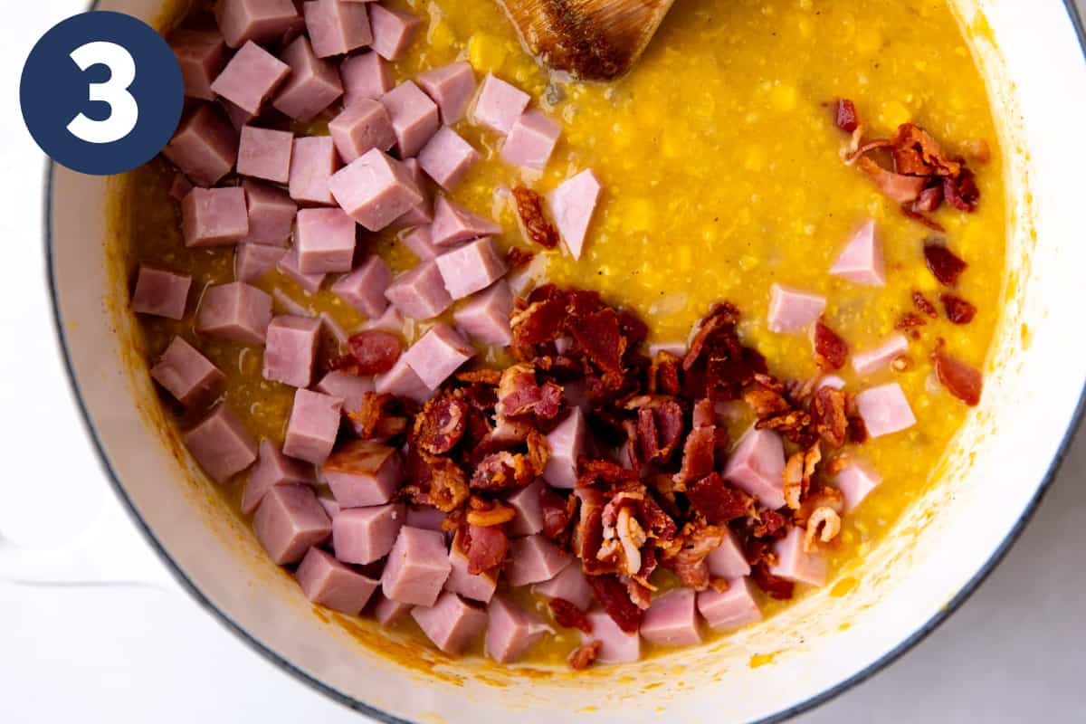 Diced ham and cooked bacon being added to corn chowder.