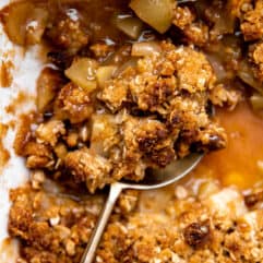 Baked apple crisp being served with a large spoon.