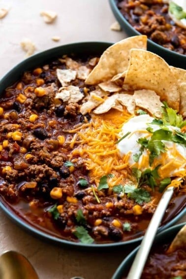Bowl of taco soup served with cheese, sour cream and tortilla chips.
