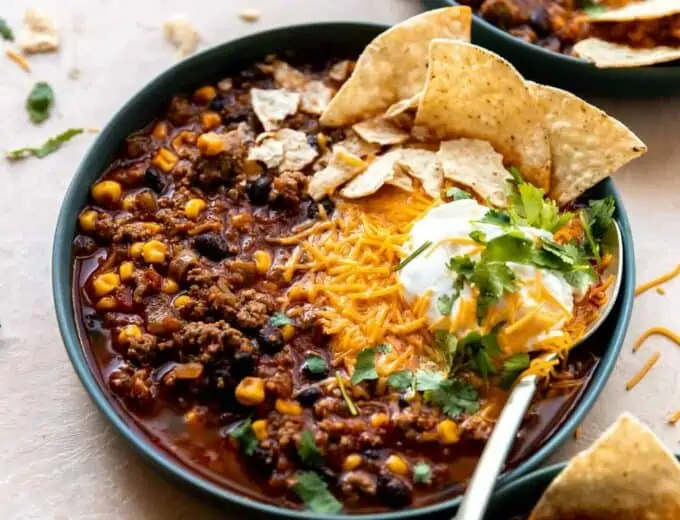 Bowl of taco soup served with cheese, sour cream and tortilla chips.