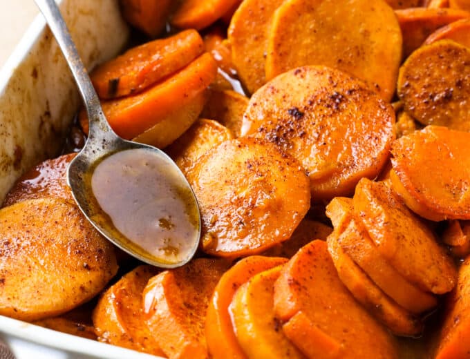 Baked candied sweet potato in a white baking dish.