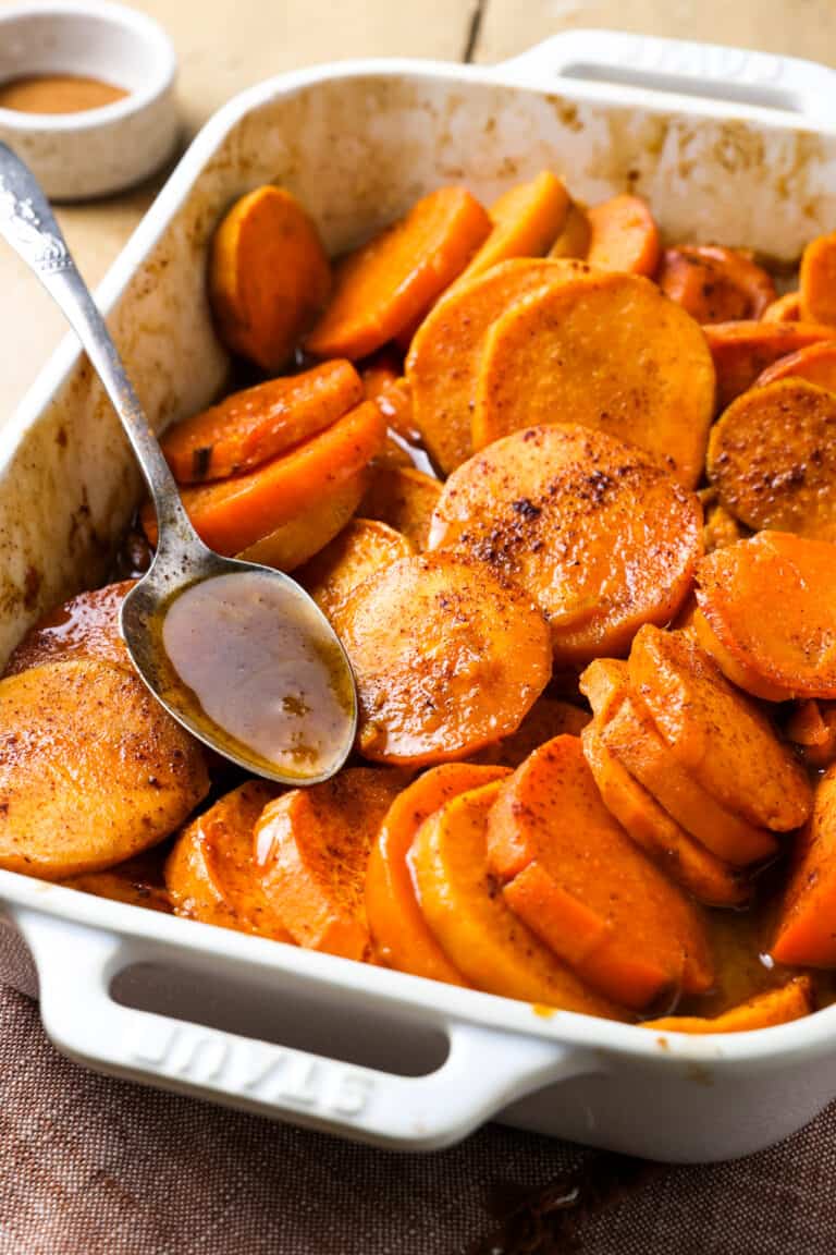 Baked candied sweet potato in a white baking dish.