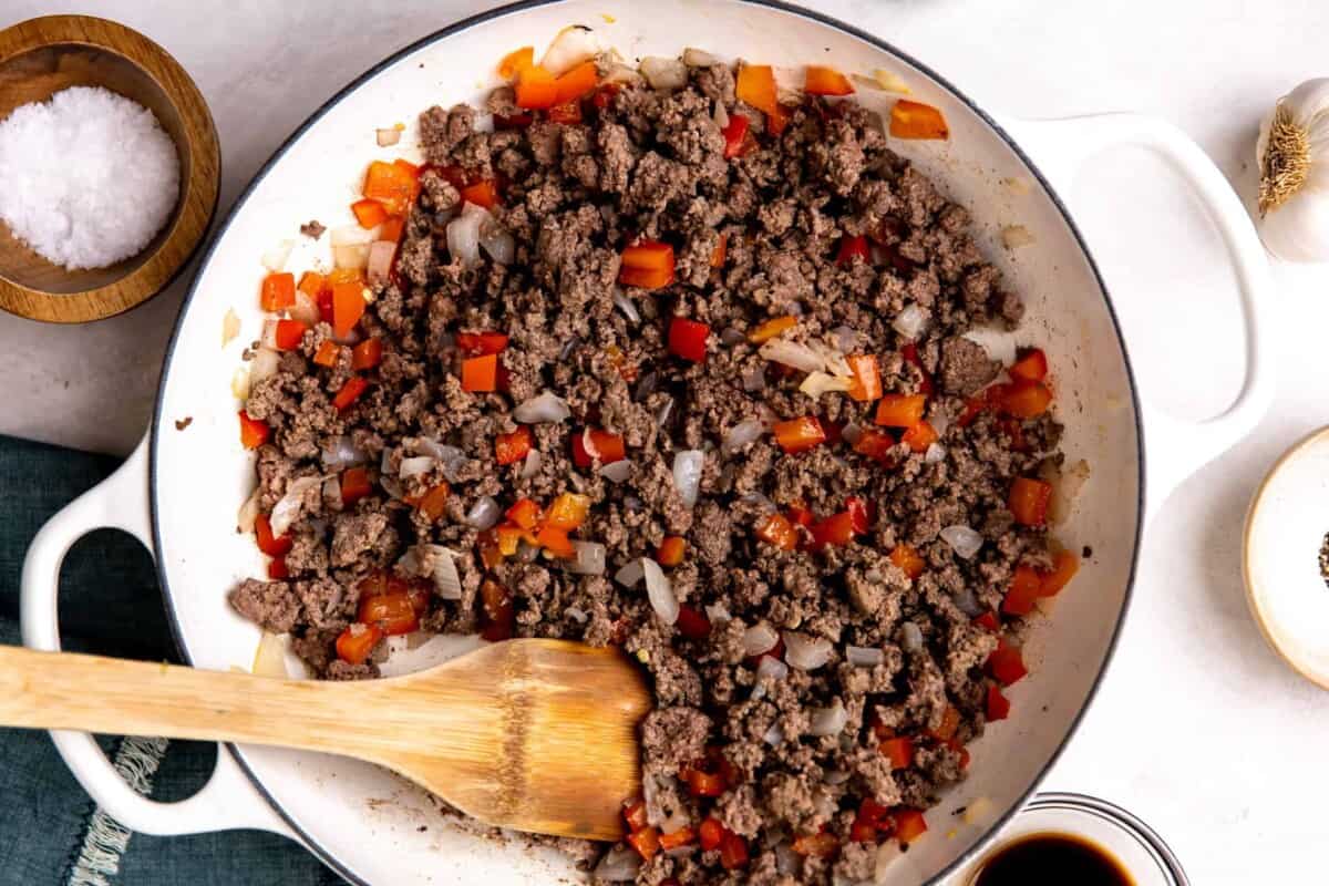 Ground beef and veggies cooking in a skillet.