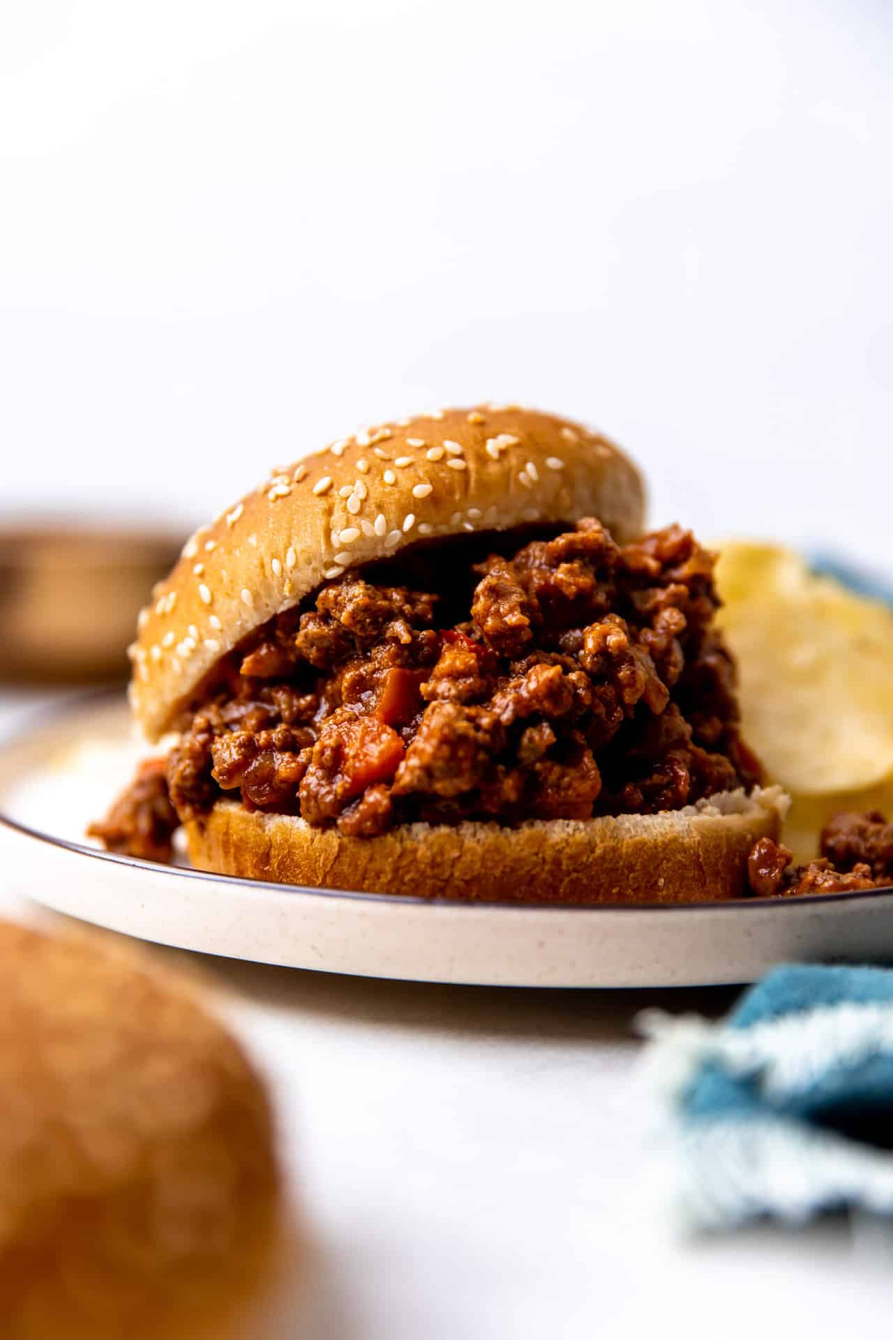 Sloppy Joes with homemade sauce on a hamburger bun served with potato chips.