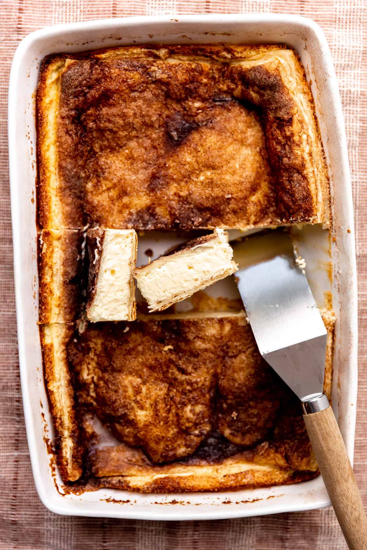 Pan of sopapillas cheesecake sliced into bars and ready to be served. 