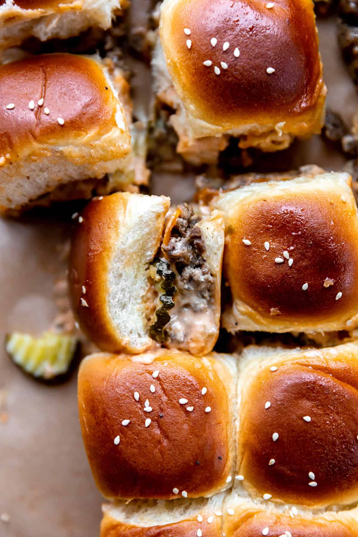 Overhead of pull apart sliders on Hawaiian rolls with ground beef, cheese and pickles. 