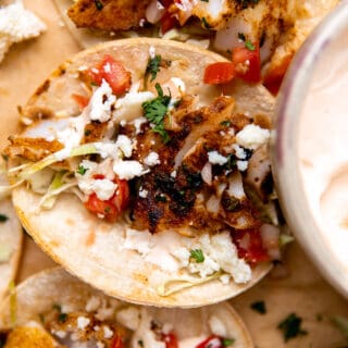 Tortillas filled with cut seasoned and seared cod, cabbage, tomatoes and queso.
