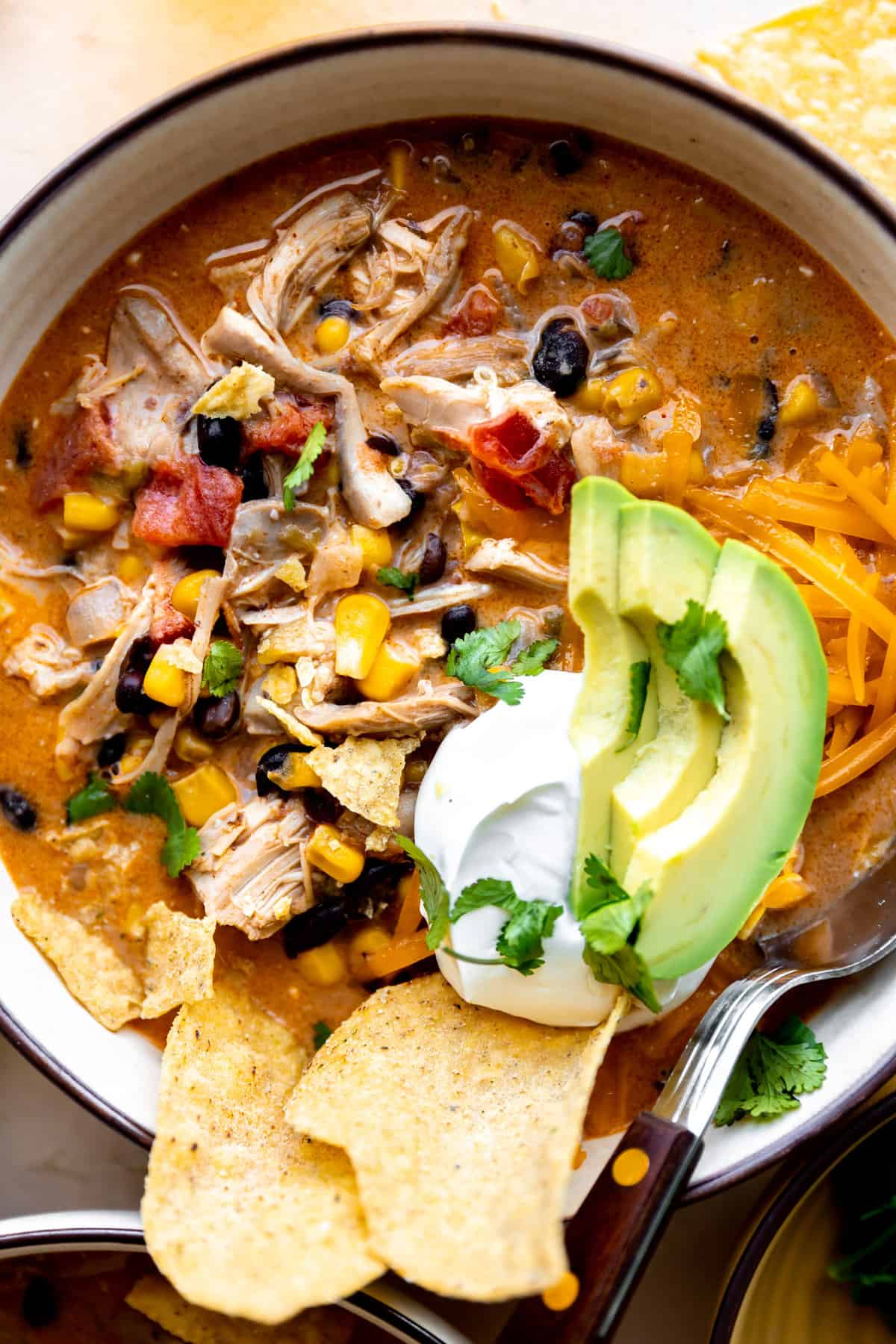 Up close of a bowl of chicken taco soup showing all ingredients in a creamy broth.