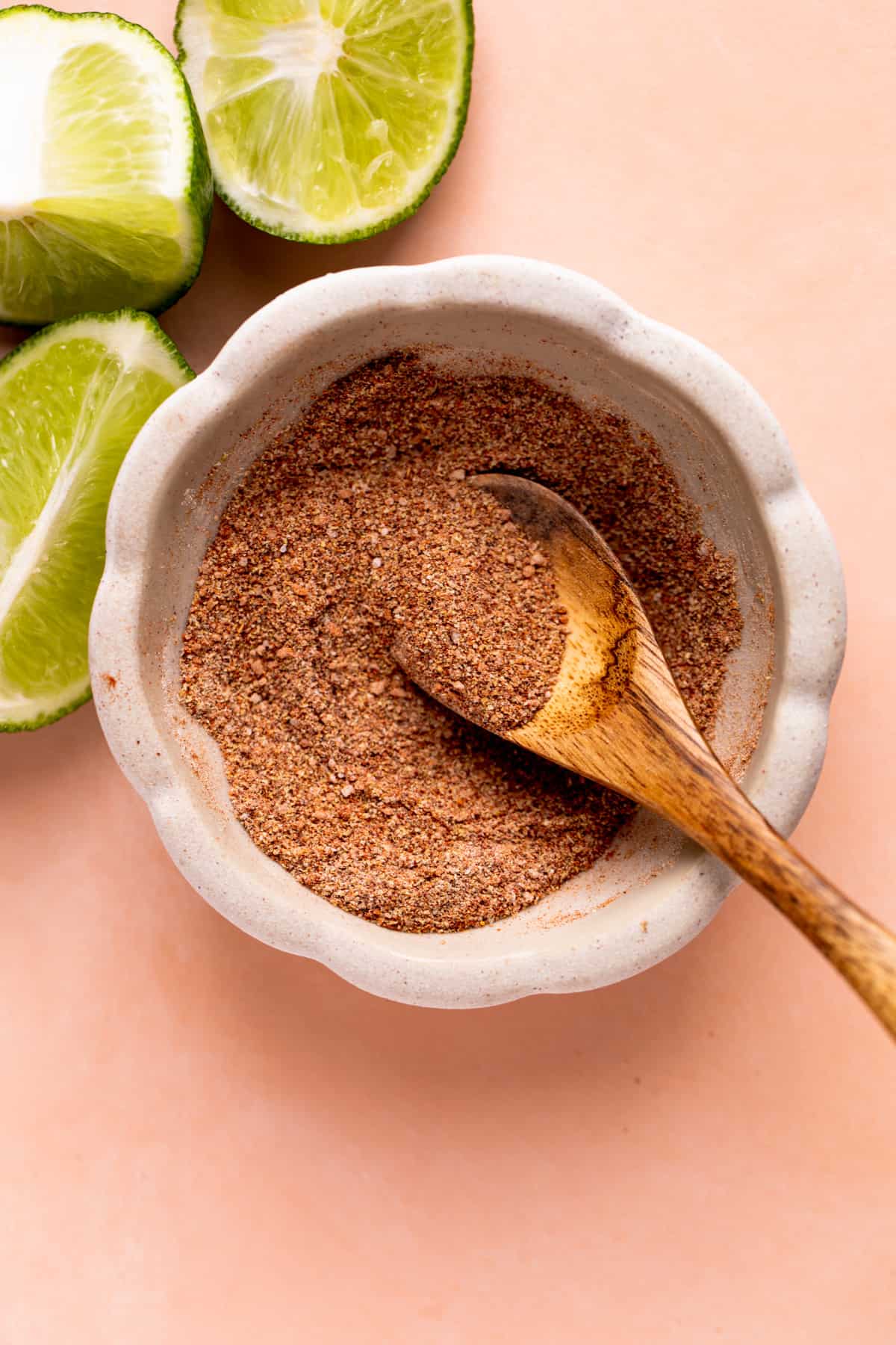 Bowl of fish taco seasoning mixed with a wooden spoon.